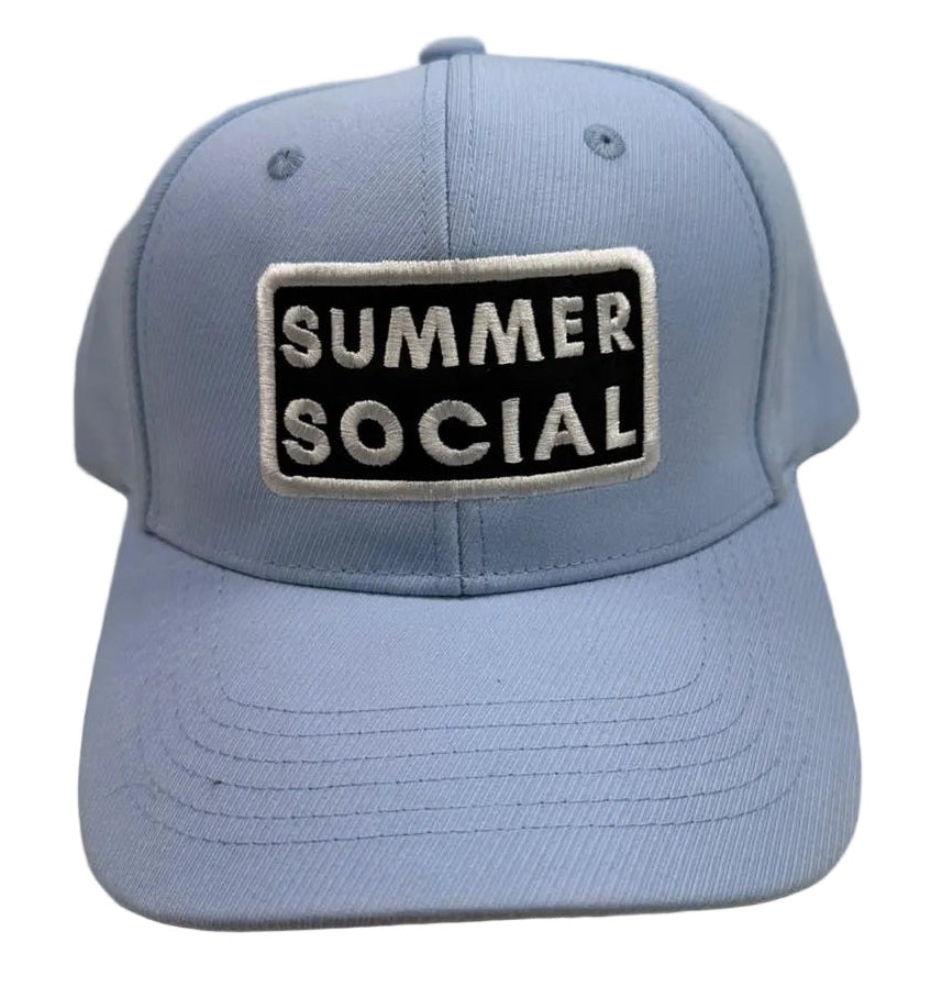 Blue cap with 'Summer Social' patch on a beige background